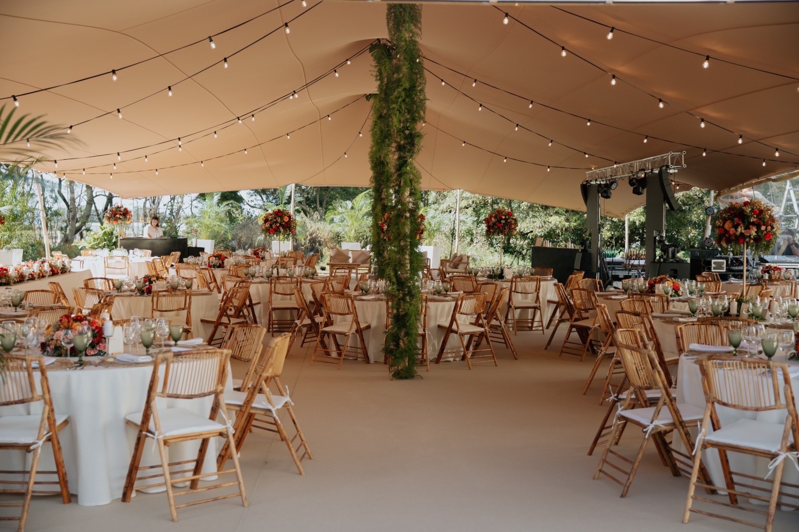 una carpa llena de mesas y sillas en la noche