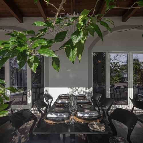 a dining room with black chairs and a table set with plates and glasses