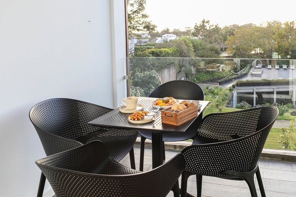 una mesa y sillas negras con comida encima