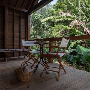 a director 's chair sits on a wooden deck next to a table