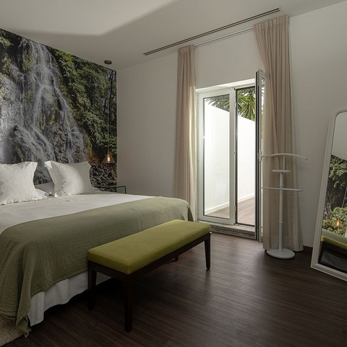 a bedroom with a waterfall wallpaper on the wall
