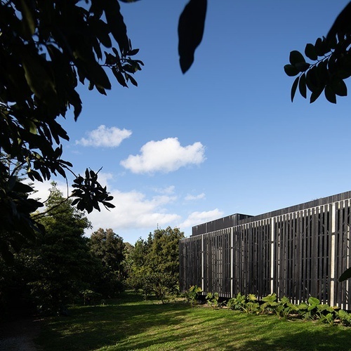 a black and white building with a blue sky in the background
