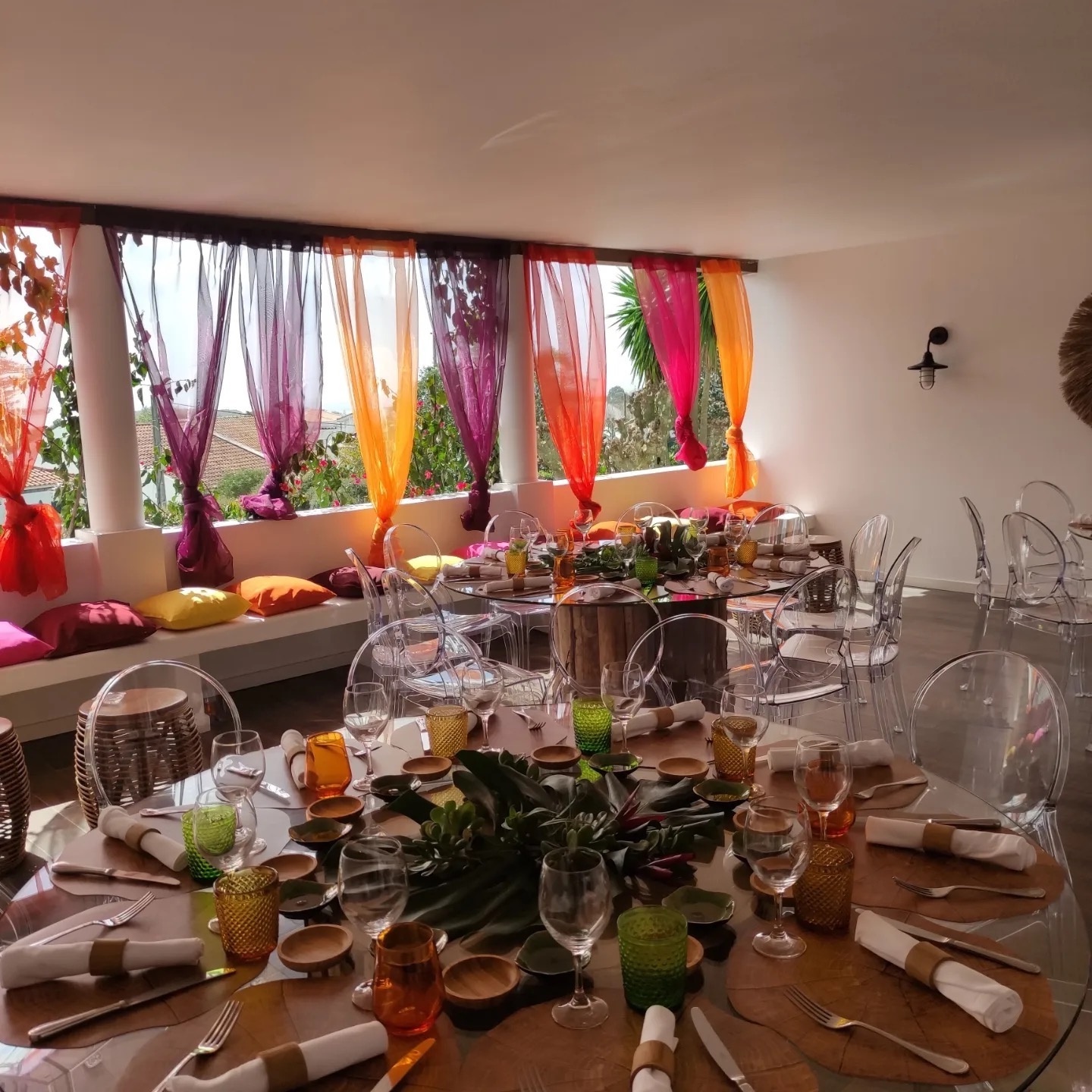 uma sala de jantar com mesas e cadeiras e cortinas coloridas