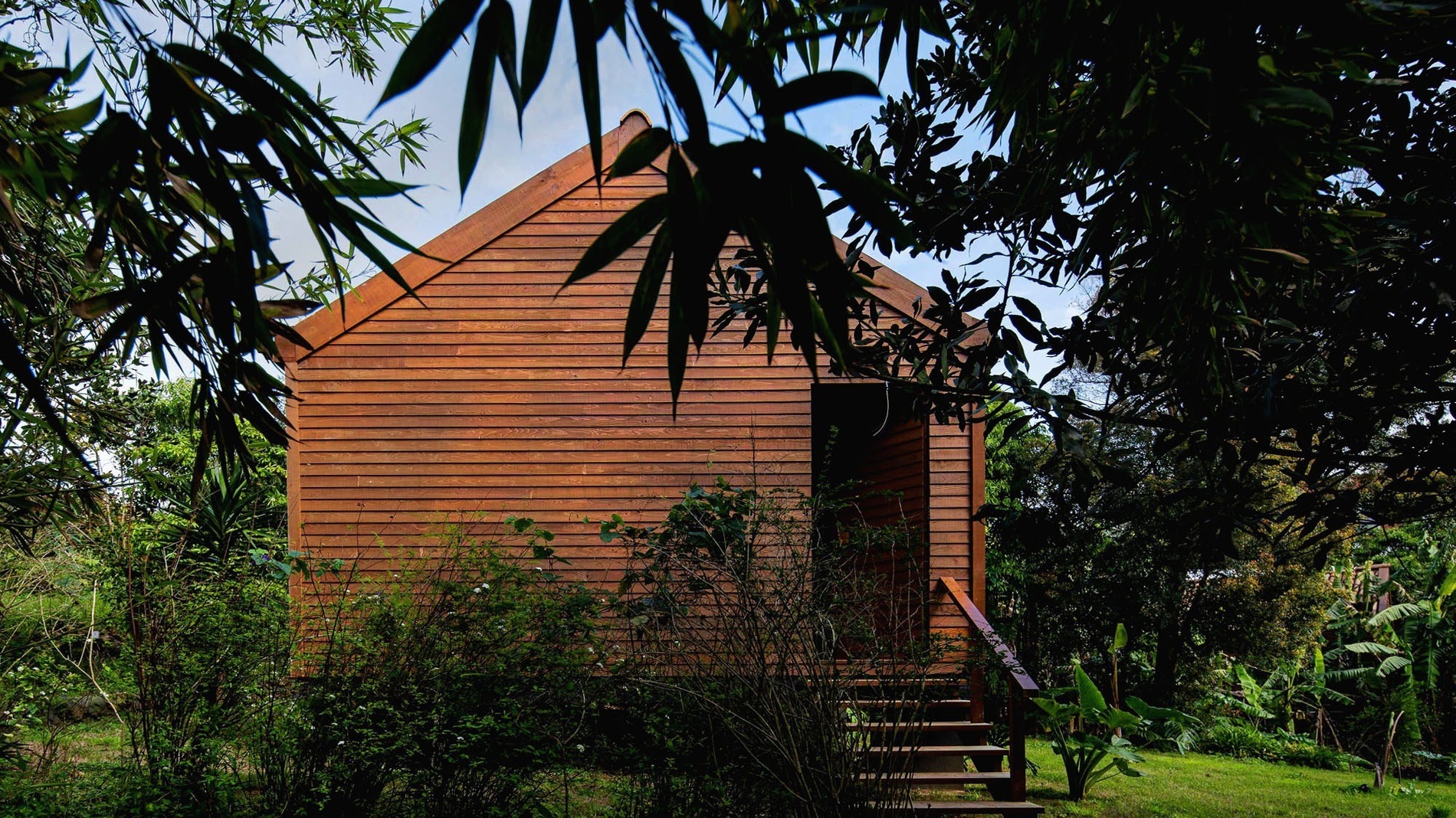 a small wooden house is surrounded by trees and bushes