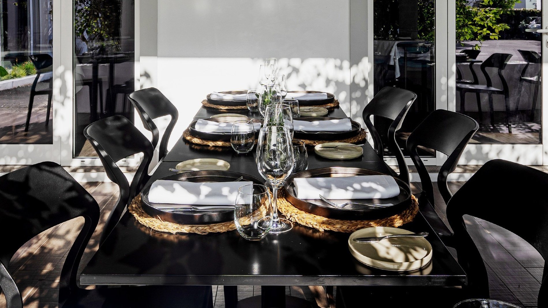 uma mesa de jantar preta com pratos e taças