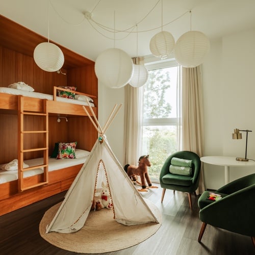 a bedroom with a bunk bed and a green chair