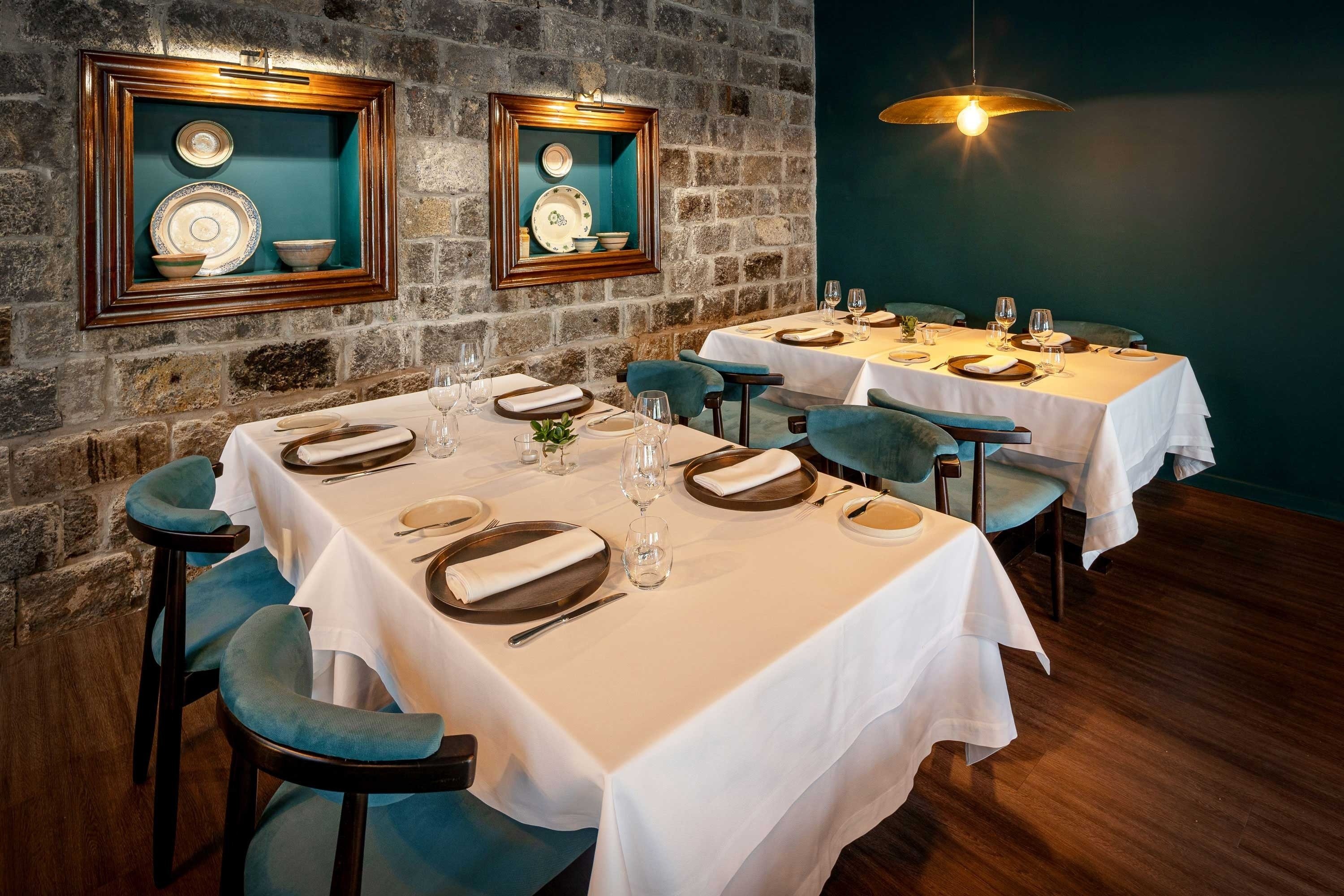 uma sala de jantar com mesas e cadeiras e pratos na parede