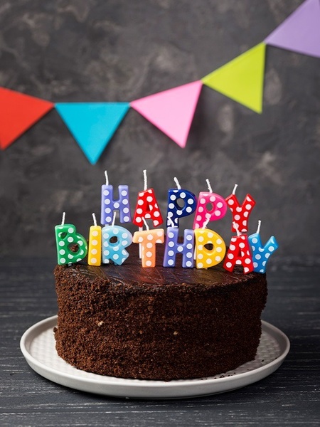 ein Schokoladenkuchen mit bunten Geburtstagskerzen darauf