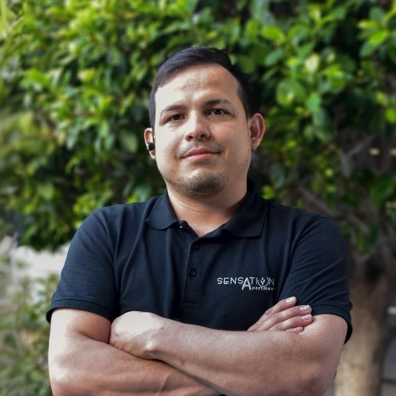  un hombre con los brazos cruzados y una camisa negra que dice sensación 