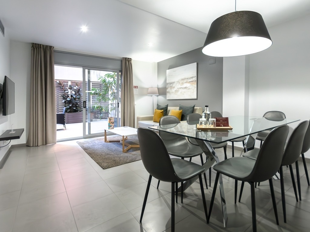 a living room with a glass dining table and chairs