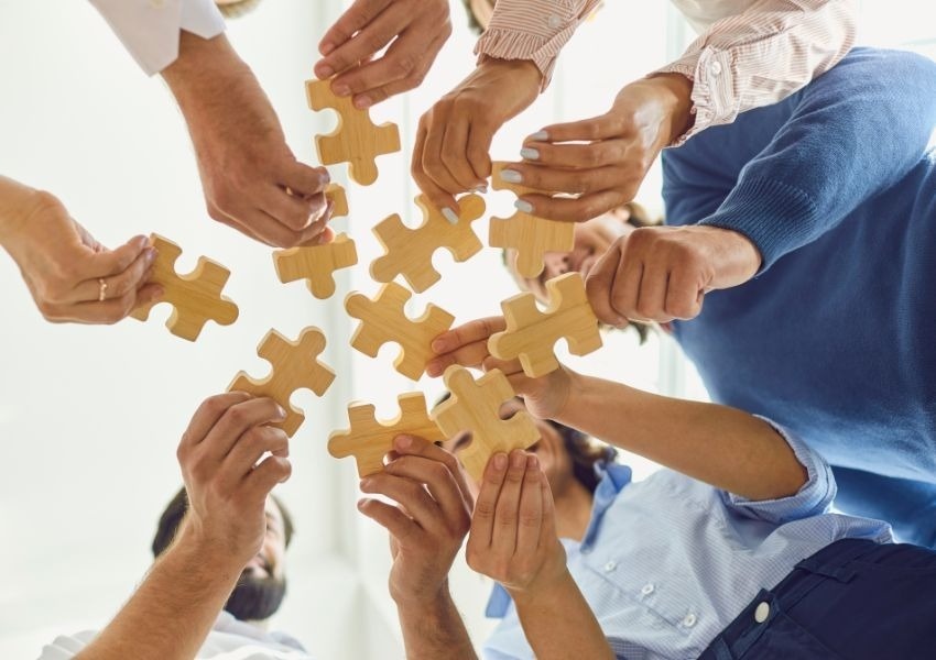 a group of people are putting their hands together