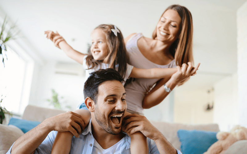 un homme porte une femme sur son dos et les deux sourient