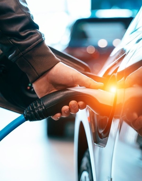 a person is charging an electric car in a garage