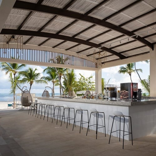 a bar with a view of the ocean and palm trees