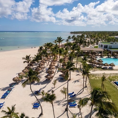 an aerial view of a beach with palm trees and a swimming pool