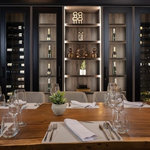 a long wooden table with wine glasses and silverware on it