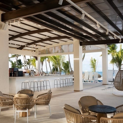 a bar with a view of the ocean and palm trees