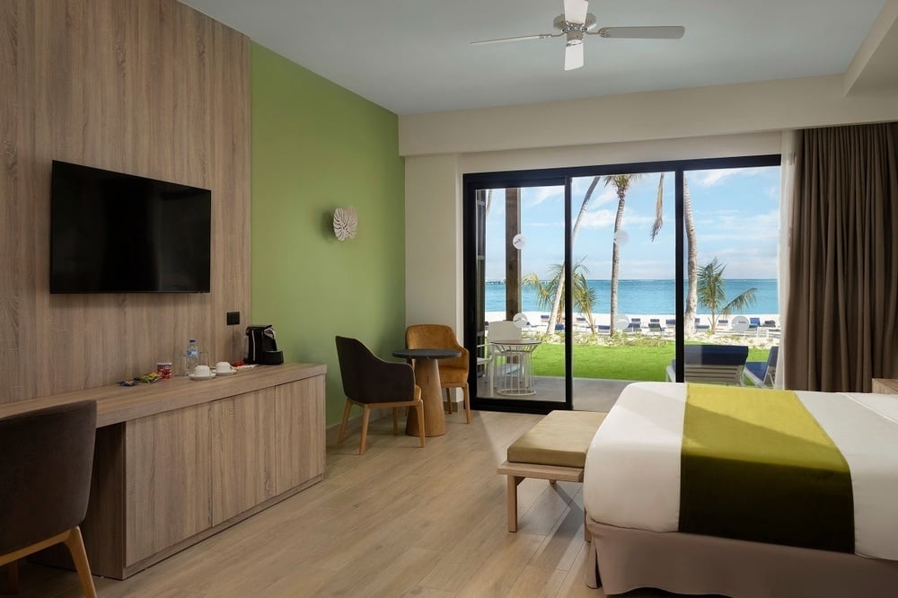 ein Balkon mit einem Tisch und Stühlen mit Blick auf ein Hotel und das Meer