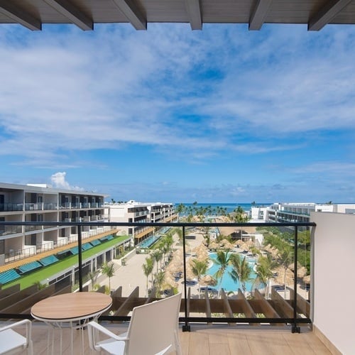 a balcony with a table and chairs overlooking a resort