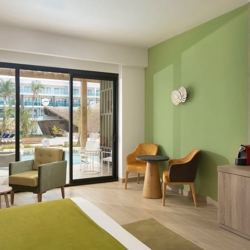a hotel room with green walls and a sliding glass door