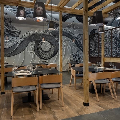 a restaurant with a mural of a dragon on the wall