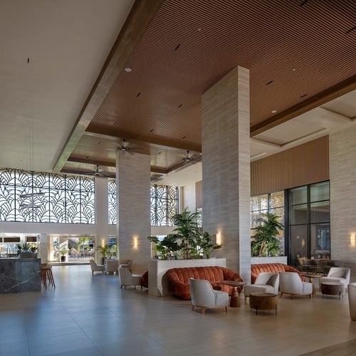 a lobby of a hotel with a couch and chairs
