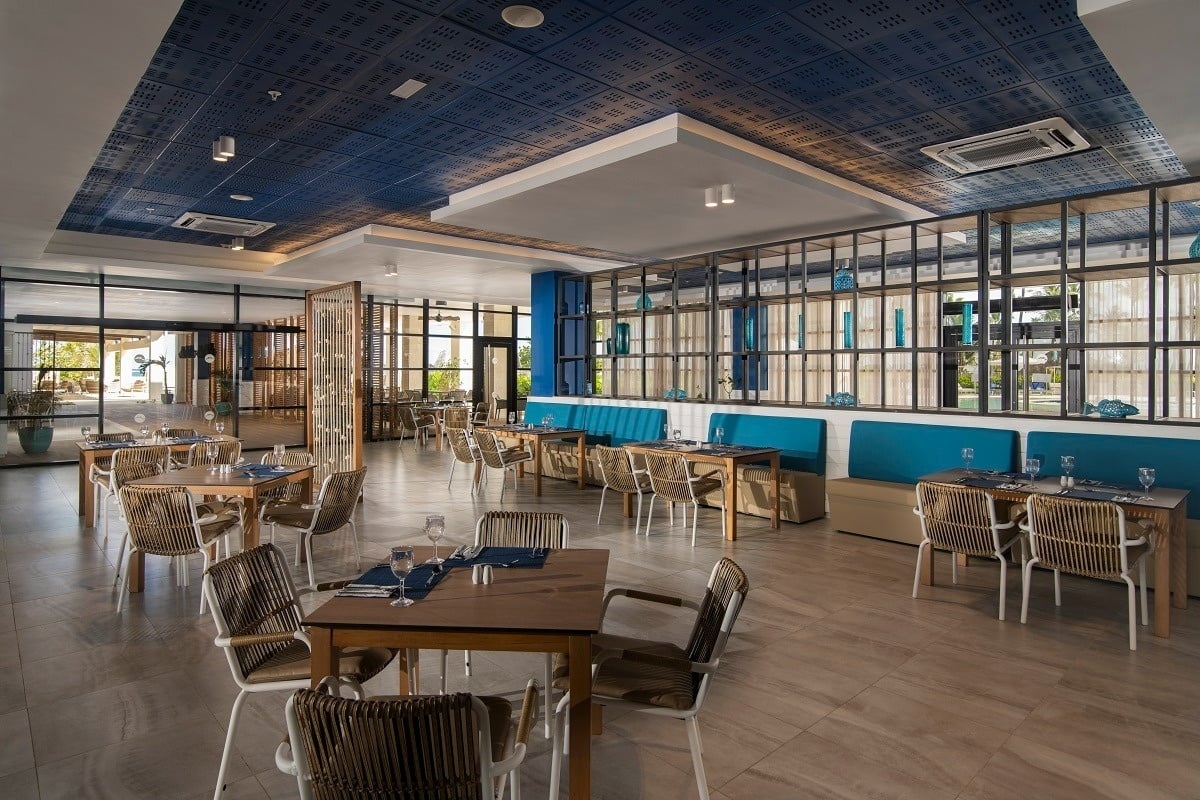 une salle à manger avec des tables et des chaises et un plafond bleu