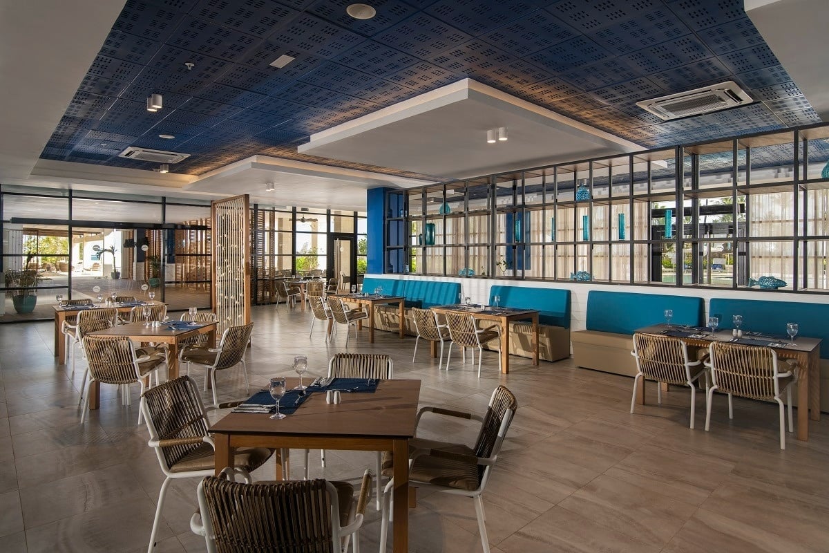 a restaurant with tables and chairs and a blue ceiling