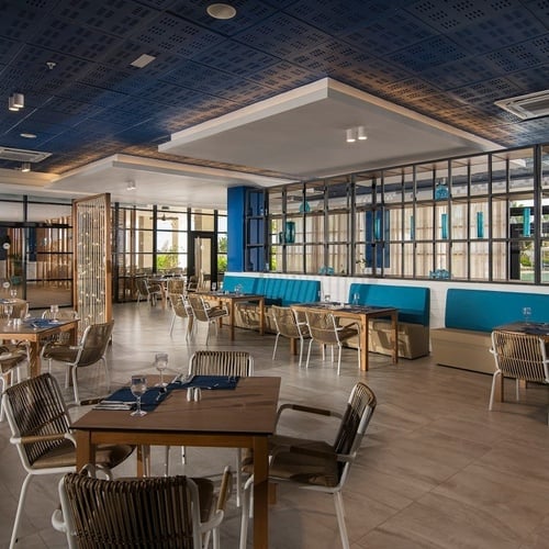 a restaurant with tables and chairs and a blue ceiling