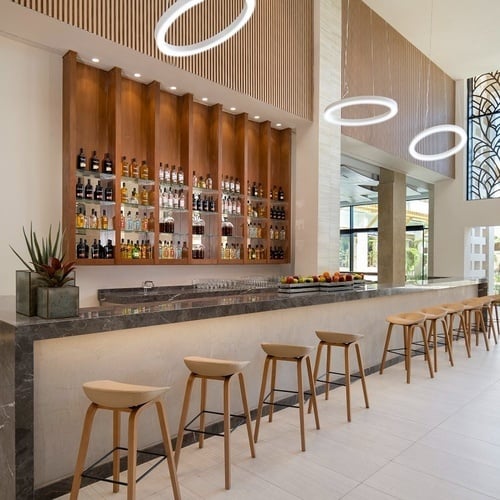 a bar with stools and bottles on the wall