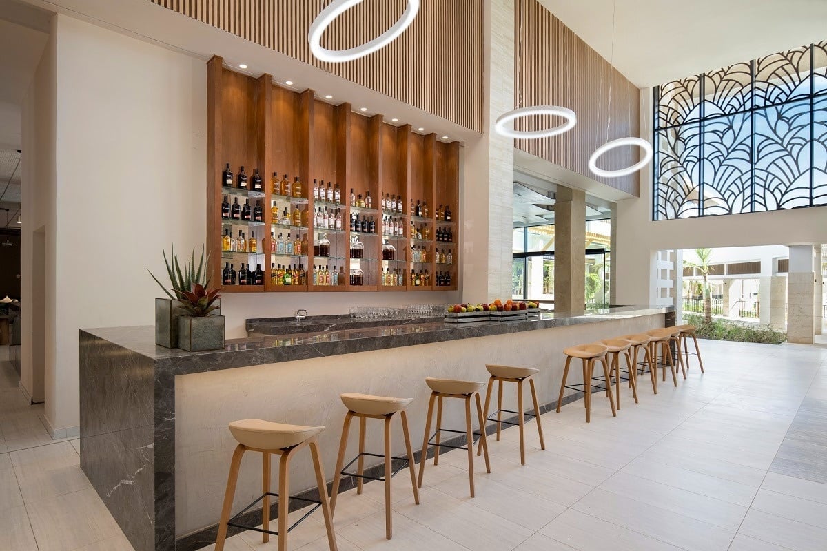 a bar with stools and bottles on the wall