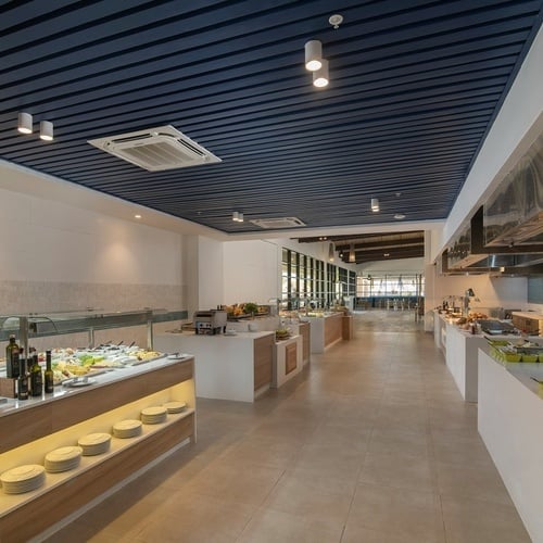 a buffet line in a restaurant with a blue ceiling