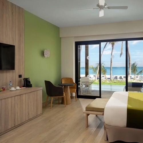 a hotel room with a large bed and a ceiling fan