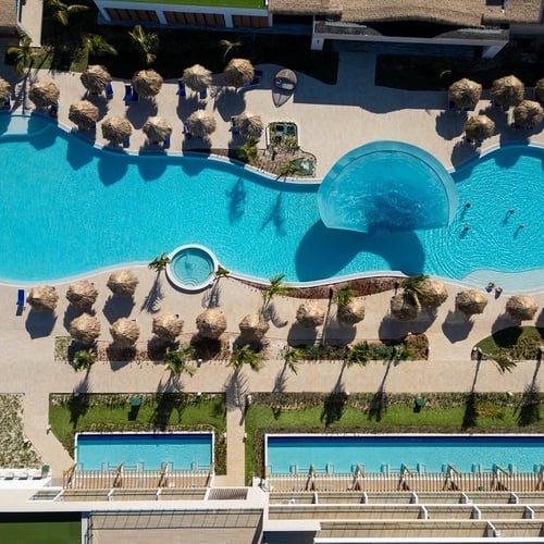 an aerial view of a large swimming pool surrounded by umbrellas