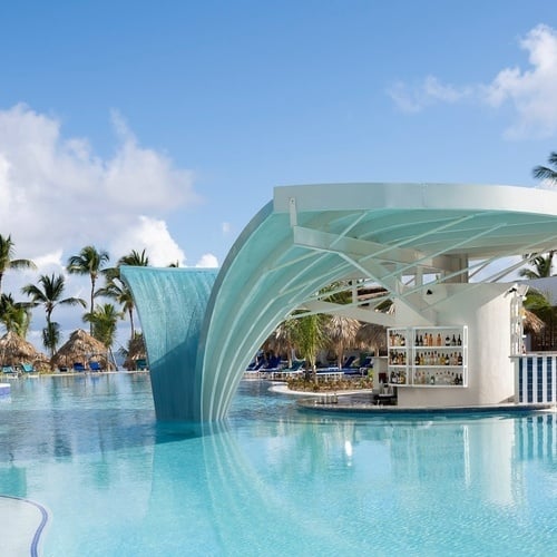 una piscina con un bar y una cascada en el medio