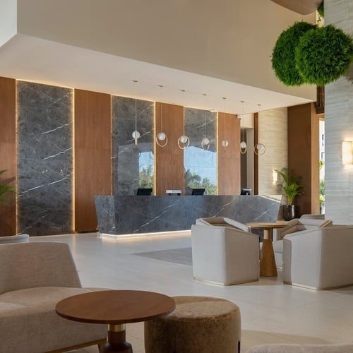 a hotel lobby with a reception desk and chairs