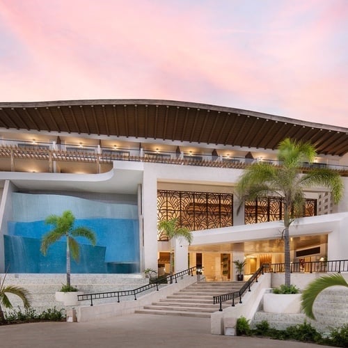 a large building with palm trees in front of it