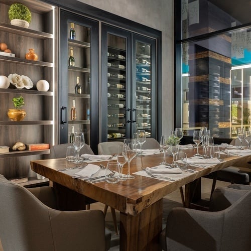 une salle à manger avec une table en bois et des verres à vin