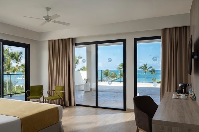 a swimming pool with a view of the ocean and palm trees