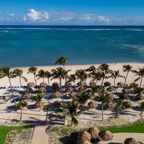 una gran piscina rodeada de sombrillas y sillas en un resort