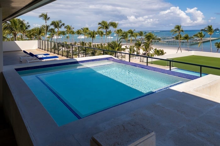a swimming pool with a view of the ocean and palm trees