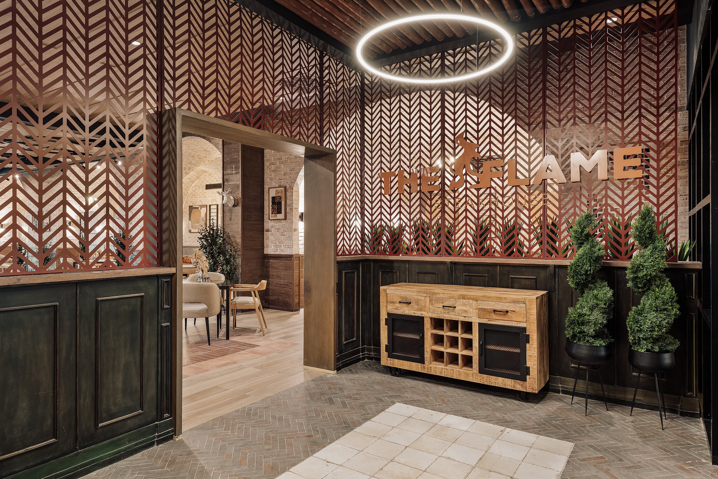 Elegant Serenade Caribe Club lobby featuring "The Flame Steakhouse" sign and plants.