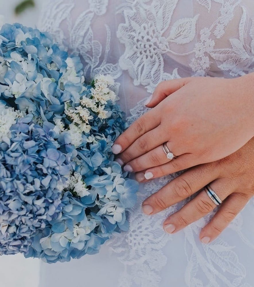 una mujer con un vestido blanco se para frente a una palmera