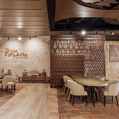 Modern steakhouse dining room with industrial decor and comfortable seating. Serenade Caribe Club