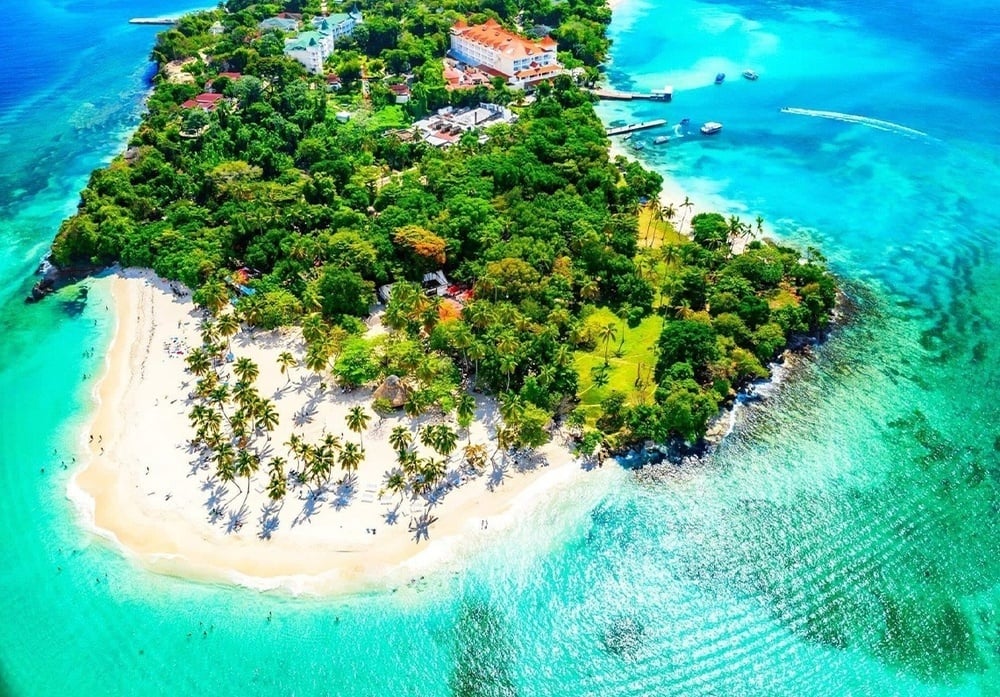 una mujer con un vestido a rayas se sienta en un sofá con vistas al océano