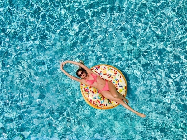 Femme sur bouée donut dans piscine. Serenade Caribe Club : détente et soleil.