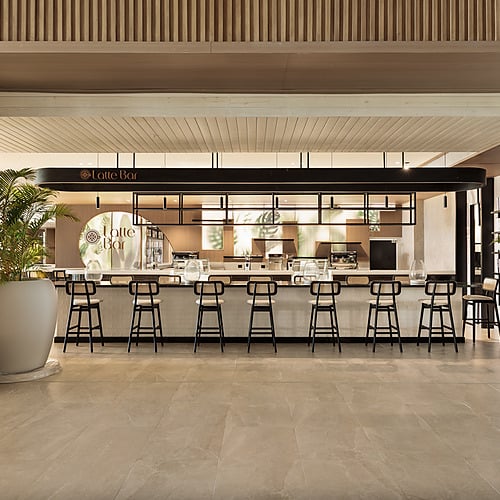 Lotte Bar at the hotel, featuring a stylish counter with stools and tropical plants Serenade Caribe Club.