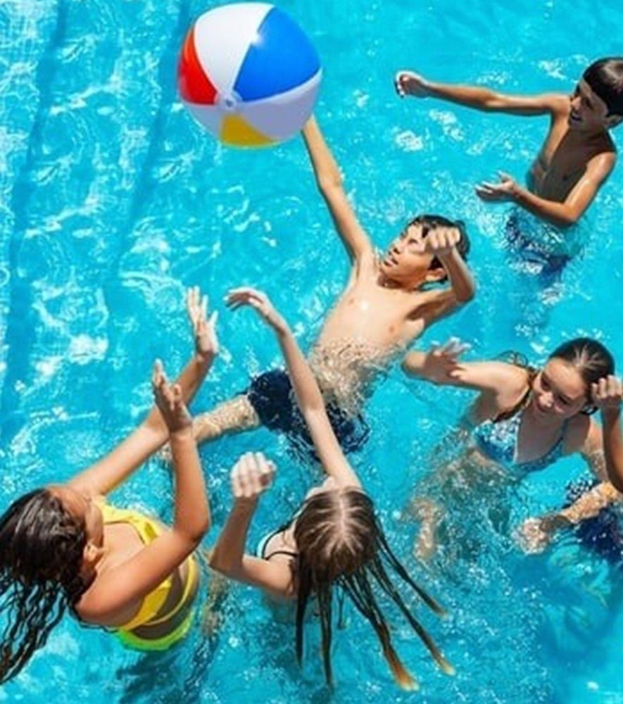 una mujer con un traje rojo está de pie junto a una piscina