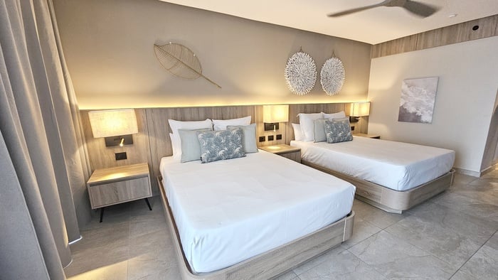 Modern suite at Serenade Caribe Club with King bed, sofa, and wall art.