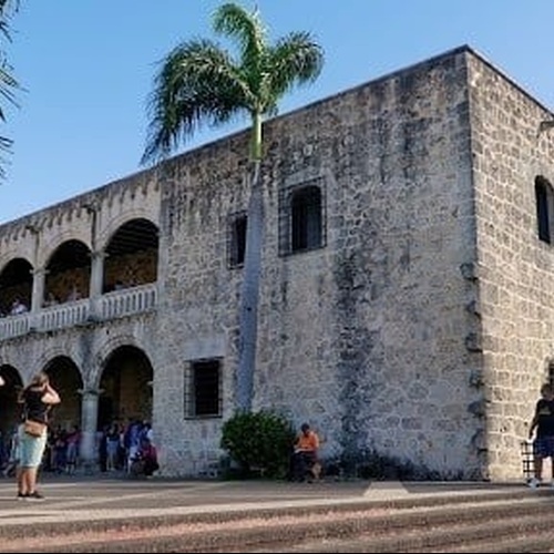 un grupo de personas está parado frente a un gran edificio de piedra .